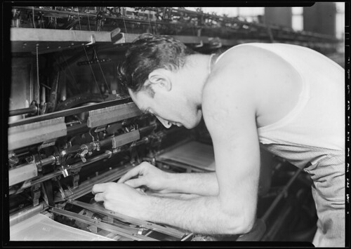 Man bending over machine, 1936