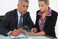 Businessman and woman using a calculator