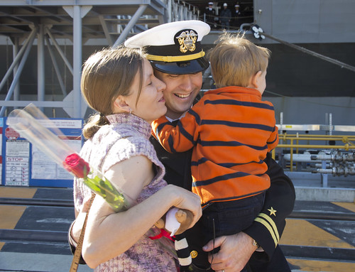 An officer hugs his children after returning home.