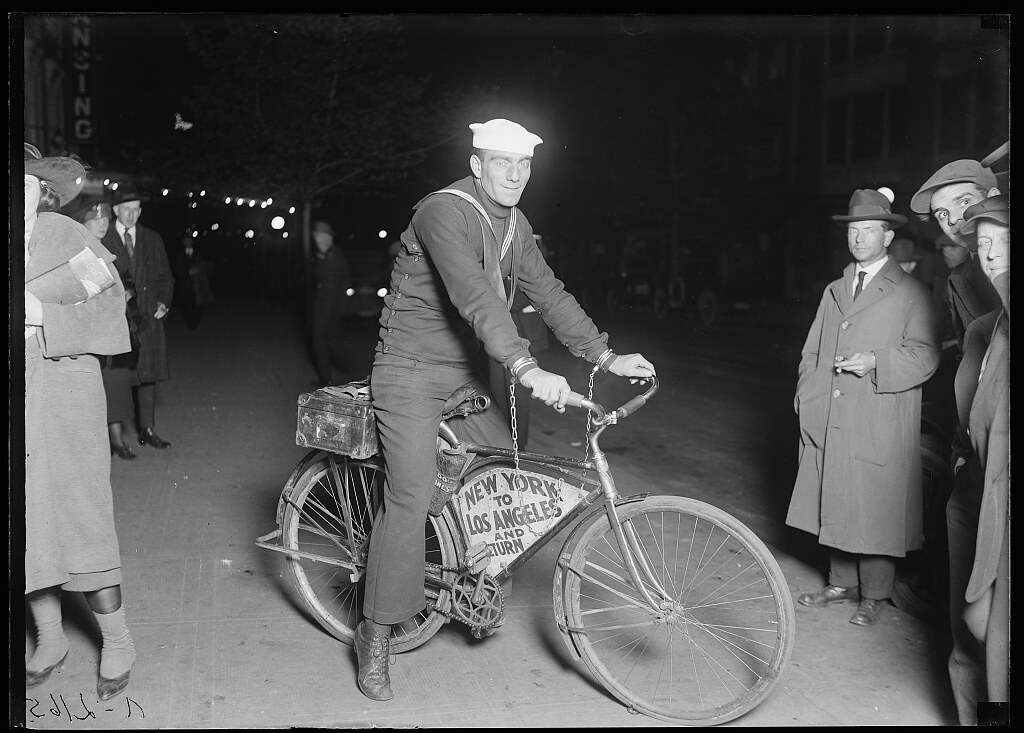 : Man with sailor hat on bicycle 