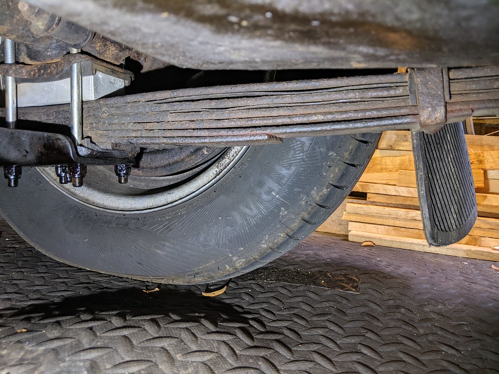 A silver block shown sitting between the rear leaf spring and axle.