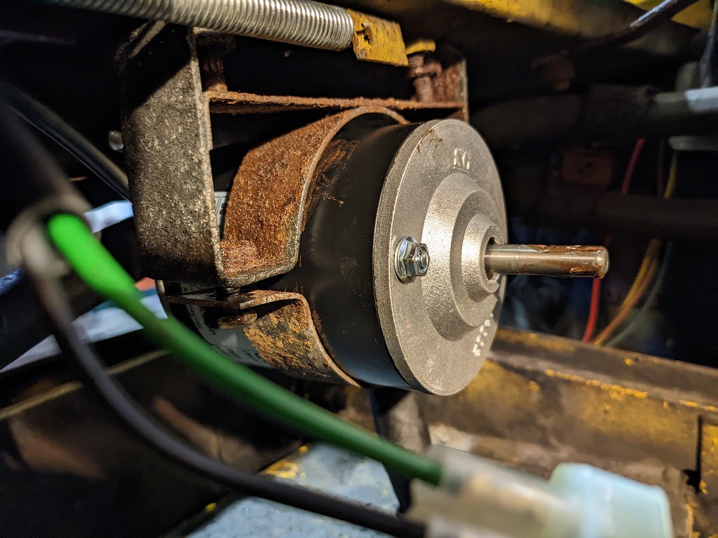 The bracket is in two halves. It is attached underneath the slam panel by the top half of the bracket with a half-circle curve to accept the motor. The second half completes the circle under the motor and bolts to the top half to allow adjustment of the motor position.