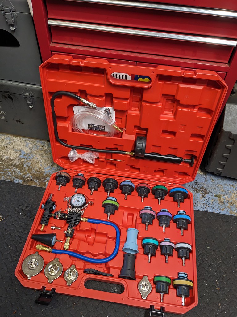 A red plastic moudled case with a couple dozen adaptor caps and other paraphenalia