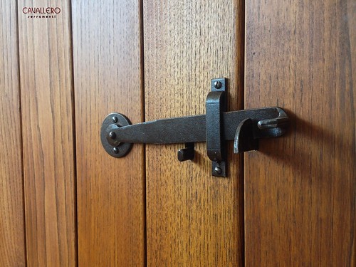 Maniglia - salterello in ferro di una porta interna in castagno con finitura ad olio