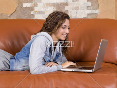 young woman using laptop on sofa