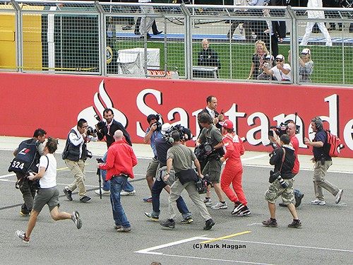 Fernando Alonso misses the drivers parade and runs to get on at the 2011 British Grand Prix