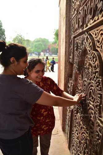 Accessible Tour of Red Fort, New Delhi: Ambika, a young blind girl trying to understand the kaarigari on the walls of the fort, by touching the designs.