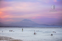 Mount Agung looms in the distance at sunset.