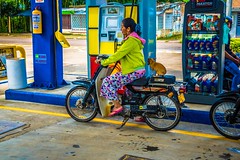 A woman and her dog, leaving the gas station.