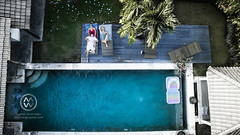 People relaxing in a pool in a Balinese villa.