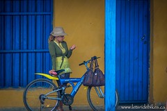 A woman checks her nails, while waiting out a rain-shower in Ciego de Avila, Cuba.